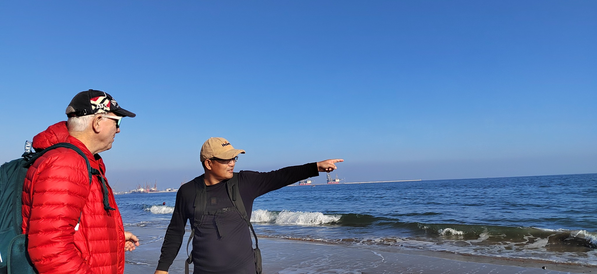 A guide pointing out the coastal scenery to a traveler
