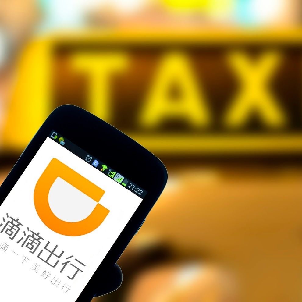 DiDi ride-hailing app in front of a taxi